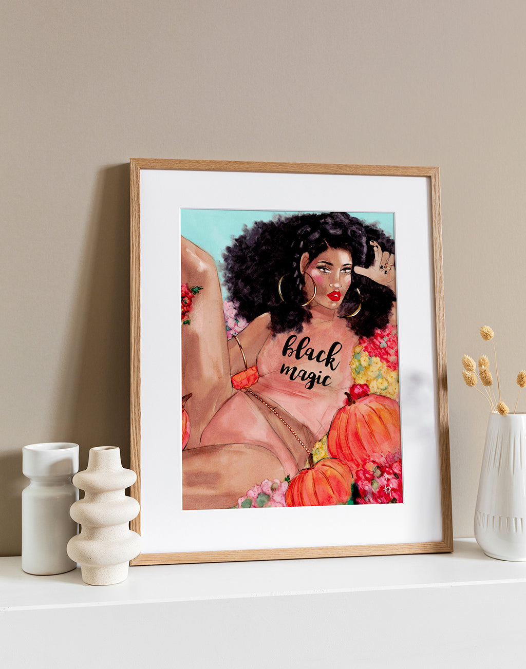 Illustration in a light frame of a beautiful woman with big curly hair wearing a black magic tee and sitting in a pumpkin patch by Tatiana Poblah